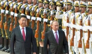 Chinese President Xi Jinping (L) and Russian President Vladimir Putin attend a welcome ceremony for Putin at the Great Hall of the People in Beijing on June 25, 2016. Editorial Credit: Kyodo News Stills via Getty Images.