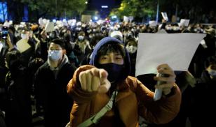 People hold white sheets of paper in protest over COVID-19 restrictions in Beijing in 2022. Crowds had gathered for a vigil honoring the victims of a fire in Urumqi, which took place during COVID-19- related lockdowns in China. (Image credit: Reuters/Thomas Peter)