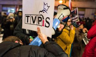 A protester holds a placard with the symbol of Poland’s Law and Justice ruling party (PiS) pasted onto the logo of the public television broadcaster TVP, during a demonstration against a proposed media advertising tax in February 2021. 