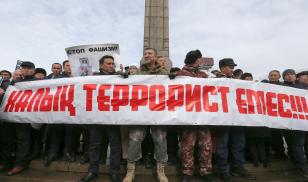 People hold a rally in memory of victims of the recent country-wide unrest triggered by fuel price increase in Almaty, Kazakhstan, February 13, 2022. A banner reads: "People are not terrorists". 