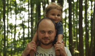 Vladimir Kara-Murza is pictured with his child on his back
